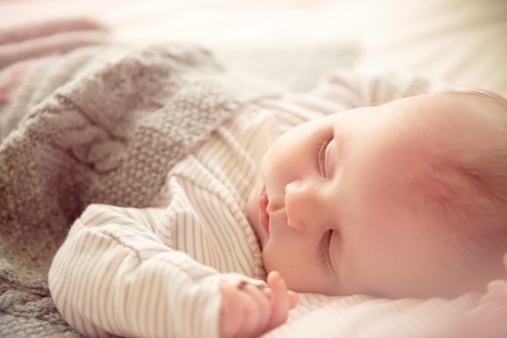 Two month old baby boy asleep in crib