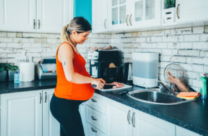 Pregnant woman in preparing food in kitchen