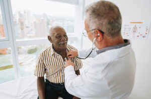 A doctor listens to a patient’s chest with a stethoscope.