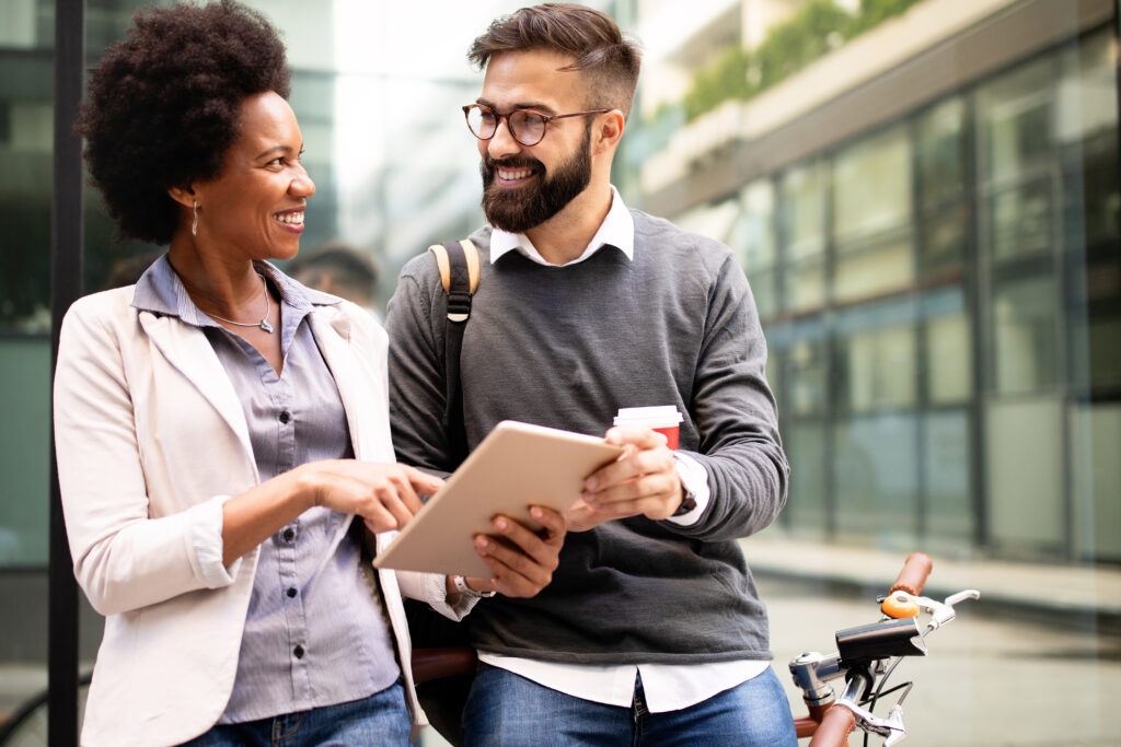 Happy business people discussing and smiling while walking together outdoor