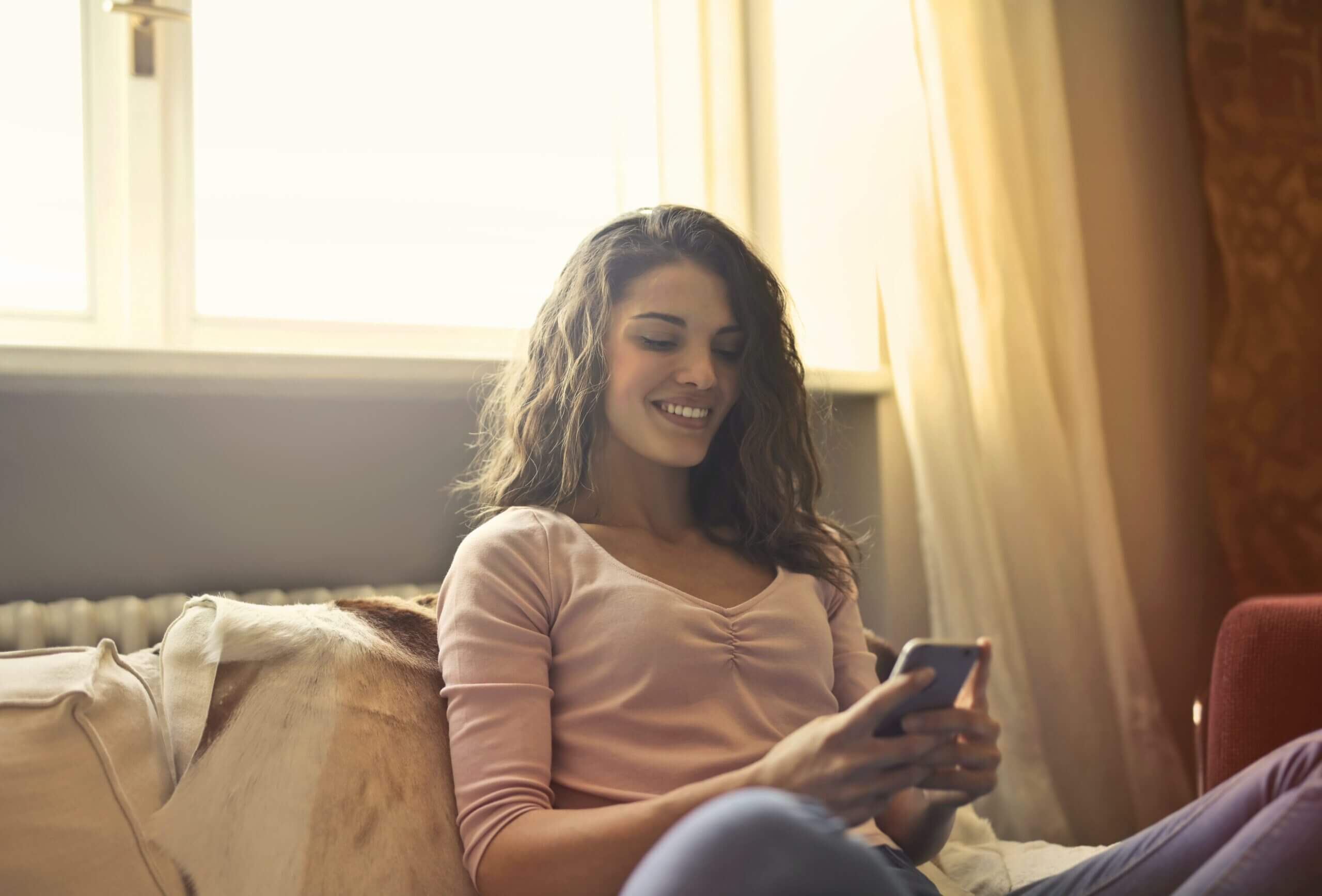 women on couch looking on castlight navigation app on phone